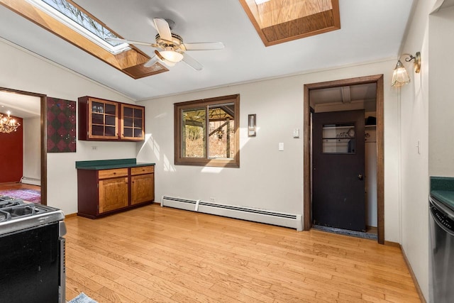 kitchen featuring light wood finished floors, a baseboard radiator, stainless steel appliances, lofted ceiling with skylight, and brown cabinets