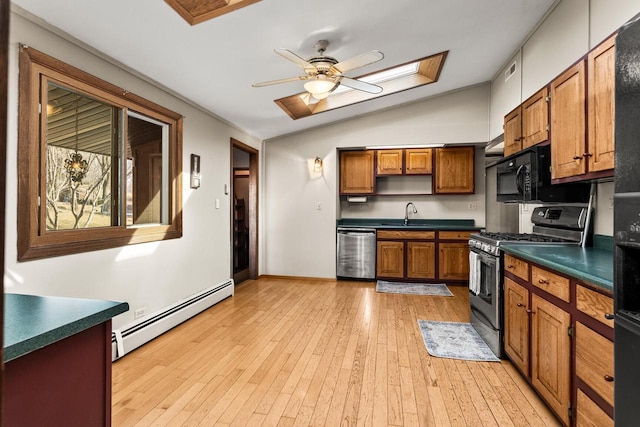 kitchen featuring dark countertops, light wood finished floors, appliances with stainless steel finishes, and a baseboard radiator