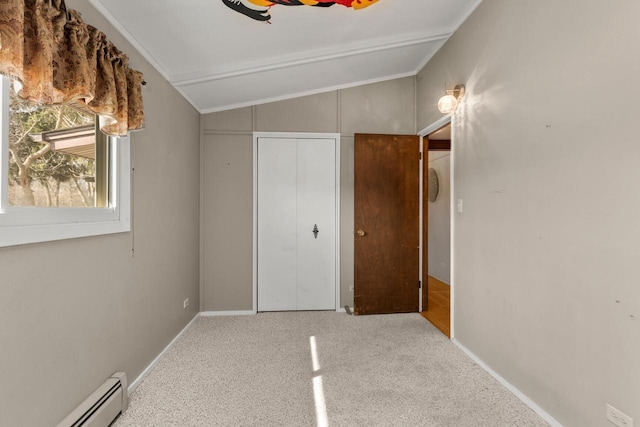 unfurnished bedroom with baseboards, carpet, lofted ceiling, a closet, and a baseboard radiator