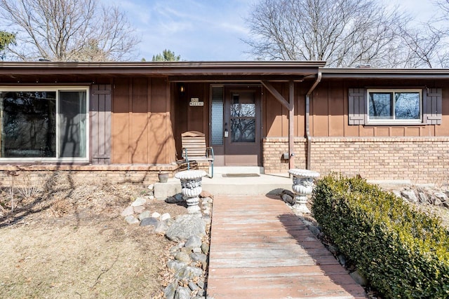 property entrance featuring brick siding and board and batten siding