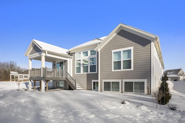 snow covered property with stairs