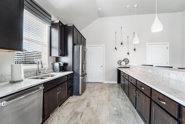 kitchen featuring a sink, stainless steel appliances, lofted ceiling, and light stone counters