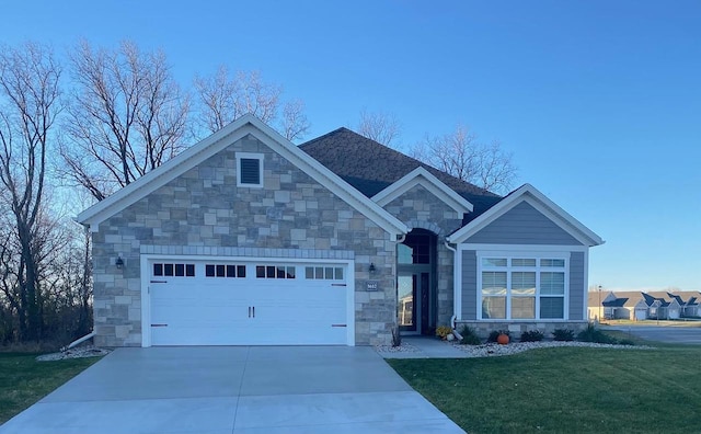 view of front of home with stone siding, a front lawn, an attached garage, and driveway