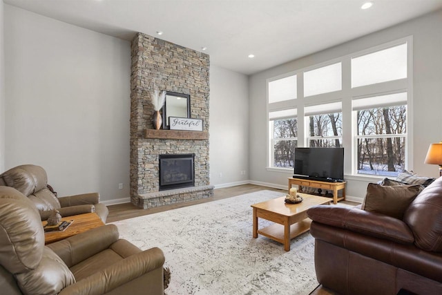 living room featuring wood finished floors, recessed lighting, a fireplace, and baseboards