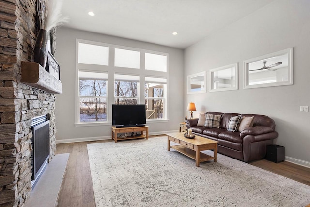 living room with recessed lighting, a fireplace, baseboards, and wood finished floors