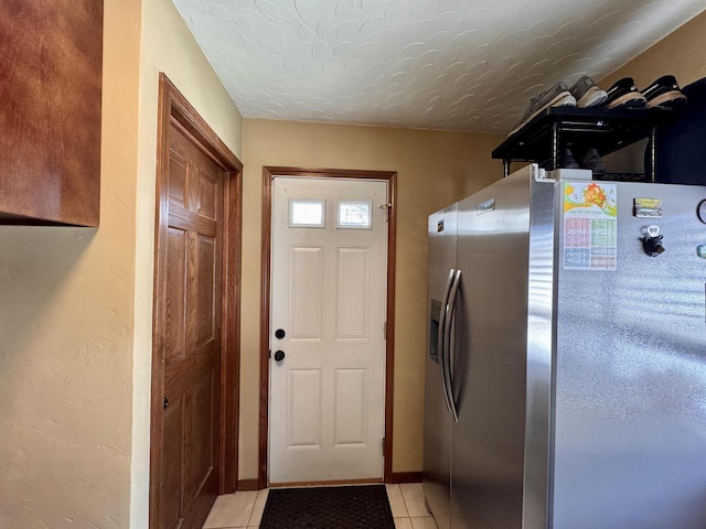 entryway with light tile patterned floors and a textured ceiling