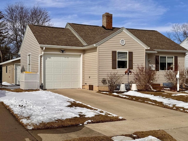 view of front of home featuring concrete driveway, an attached garage, roof with shingles, and a chimney