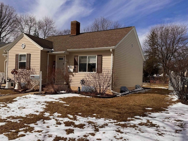 view of front of property with a chimney and a shingled roof