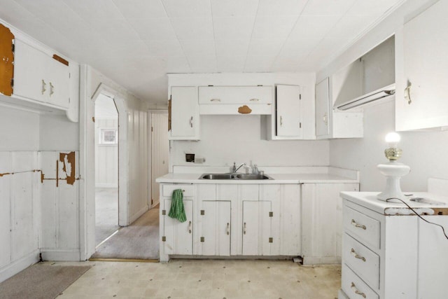 kitchen featuring a sink, white cabinets, and light countertops