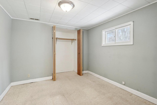 unfurnished bedroom featuring a closet, visible vents, baseboards, and carpet floors