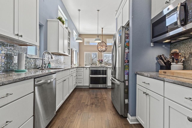 kitchen featuring backsplash, appliances with stainless steel finishes, dark wood-style floors, white cabinets, and stone countertops