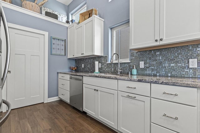 kitchen with dark wood-style floors, a sink, white cabinets, appliances with stainless steel finishes, and tasteful backsplash