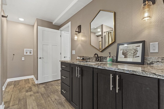 bathroom featuring vanity, wood finished floors, and baseboards