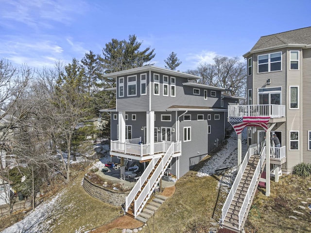 back of house featuring stairs, a patio area, and a wooden deck