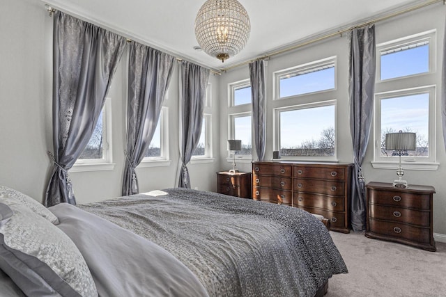 bedroom with a chandelier, carpet flooring, and multiple windows