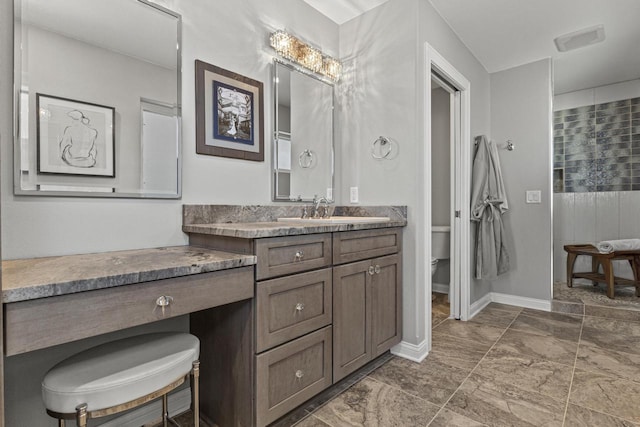 full bathroom featuring vanity, toilet, baseboards, and tiled shower