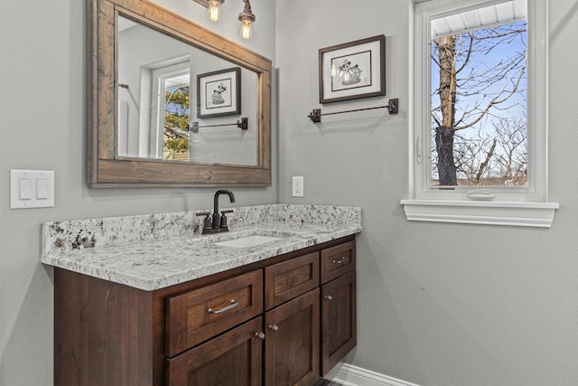 bathroom with vanity, plenty of natural light, and baseboards