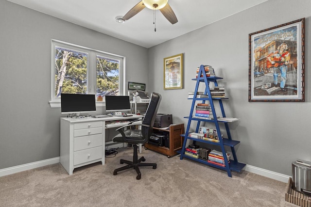 office space with light colored carpet, a ceiling fan, and baseboards