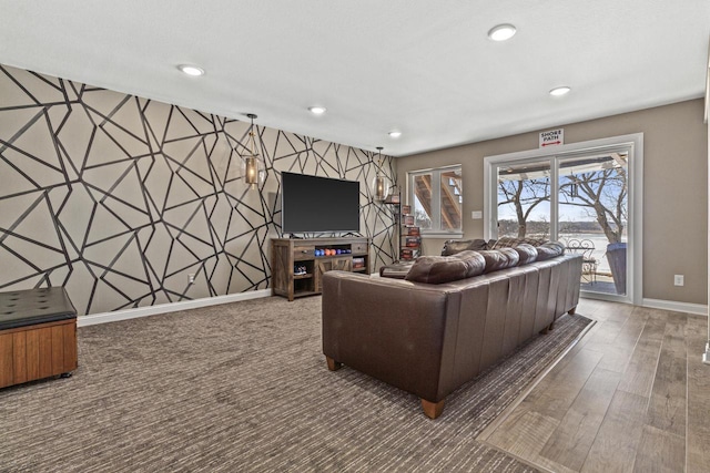 living room featuring wood finished floors, recessed lighting, wallpapered walls, baseboards, and an accent wall