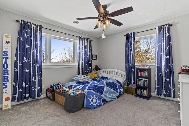 carpeted bedroom featuring baseboards and ceiling fan