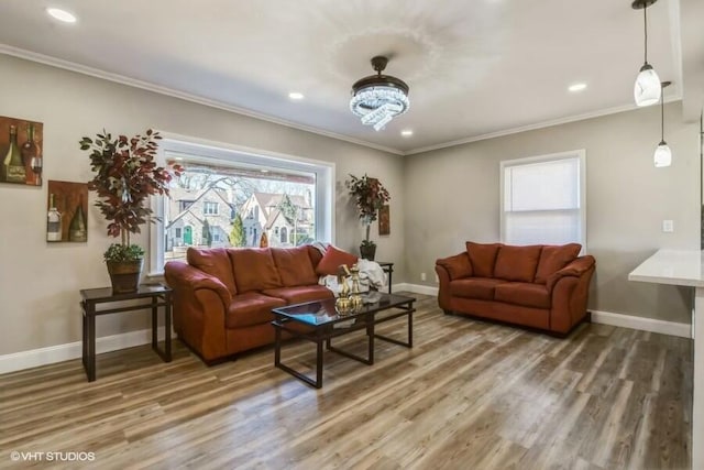 living room featuring baseboards, light wood-style flooring, and crown molding