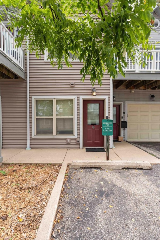 property entrance with an attached garage and a balcony