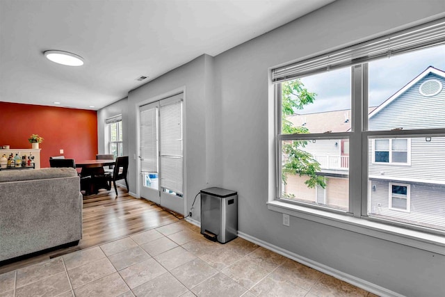 living area featuring light tile patterned floors and baseboards