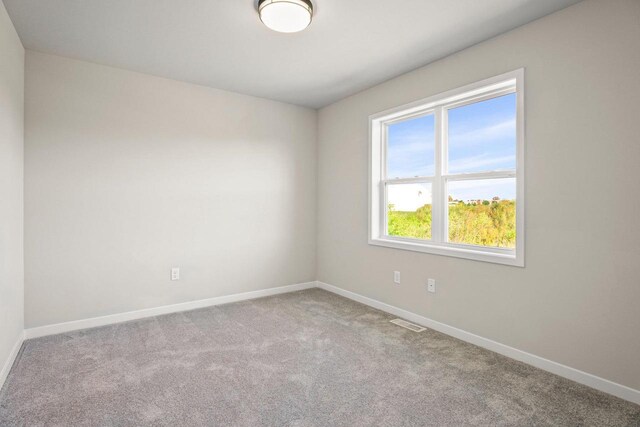 empty room with visible vents, baseboards, and carpet