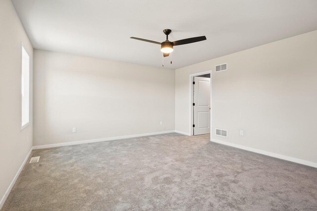 spare room with visible vents, baseboards, carpet, and a ceiling fan