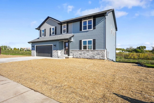 view of front facade featuring stone siding, an attached garage, and driveway