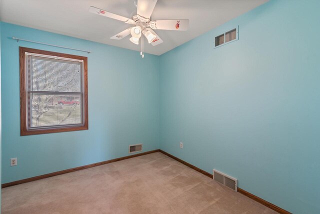 unfurnished room featuring ceiling fan, visible vents, and light carpet