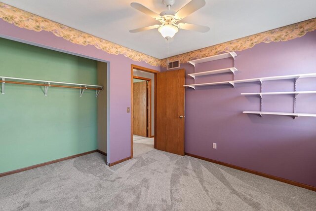 unfurnished bedroom with a closet, carpet floors, a ceiling fan, baseboards, and visible vents
