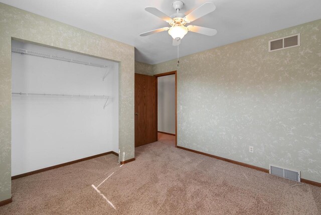unfurnished bedroom featuring a closet, baseboards, visible vents, and wallpapered walls