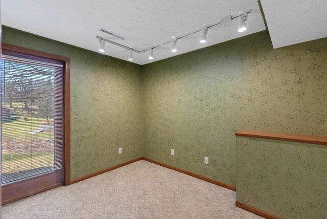 unfurnished room featuring baseboards, visible vents, and carpet