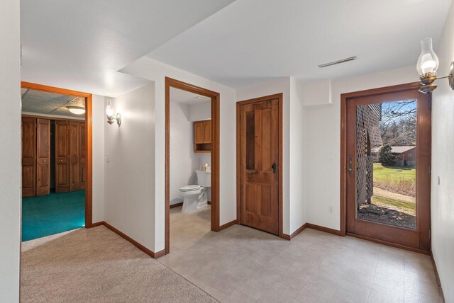 foyer entrance featuring light floors, baseboards, and visible vents