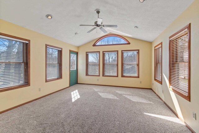 unfurnished room featuring light colored carpet, baseboards, vaulted ceiling, and ceiling fan