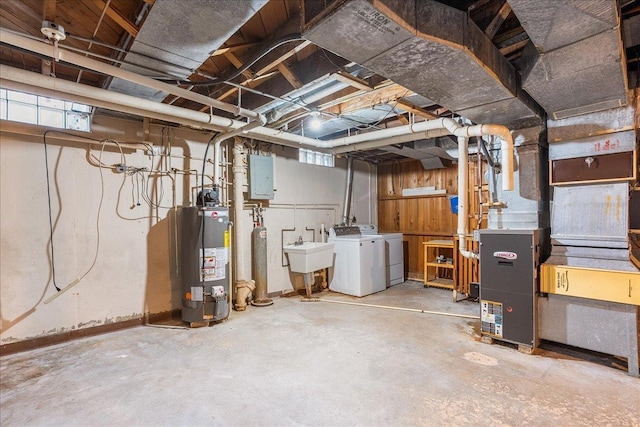 below grade area with a wealth of natural light, washer and dryer, electric panel, a sink, and gas water heater