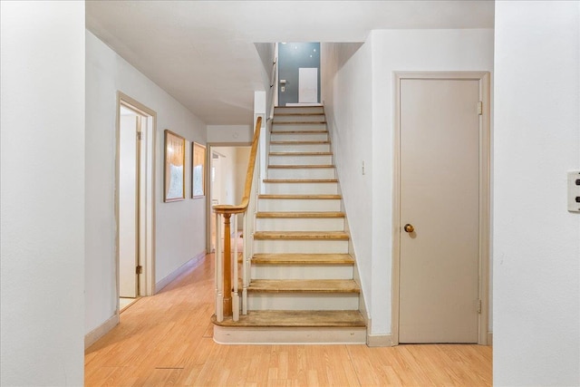 stairs with baseboards and wood finished floors