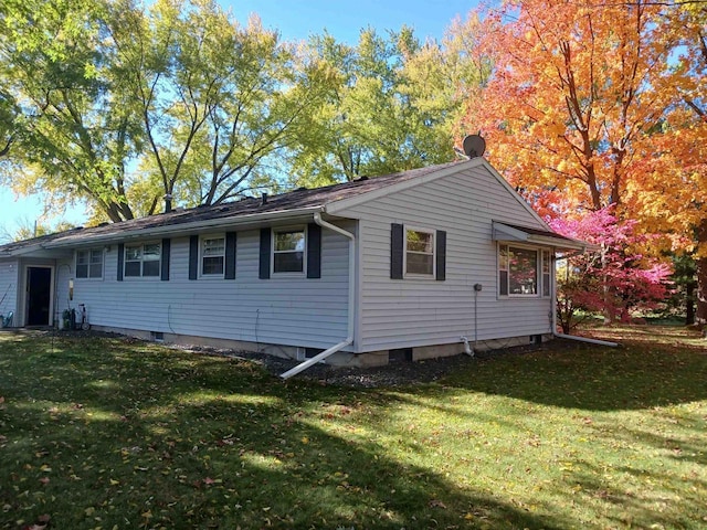 view of side of home with a yard