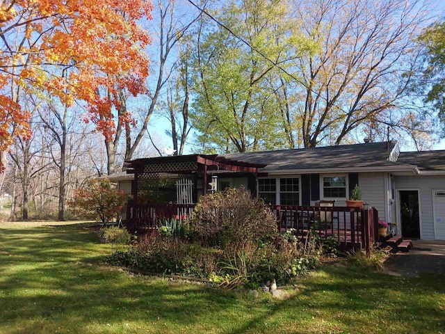 view of front facade with a wooden deck and a front lawn