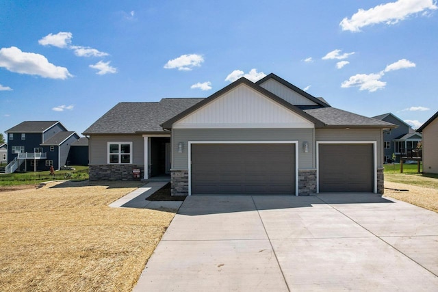 craftsman-style home with a shingled roof, a front lawn, concrete driveway, a garage, and stone siding