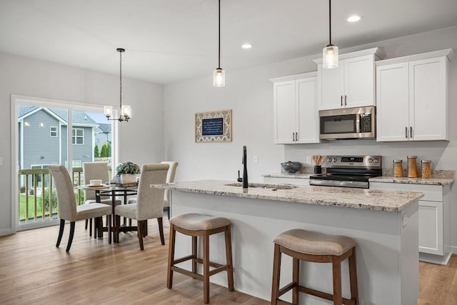 kitchen with white cabinetry, light wood-type flooring, appliances with stainless steel finishes, and a sink