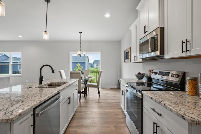 kitchen with recessed lighting, stainless steel appliances, light wood-type flooring, and a sink