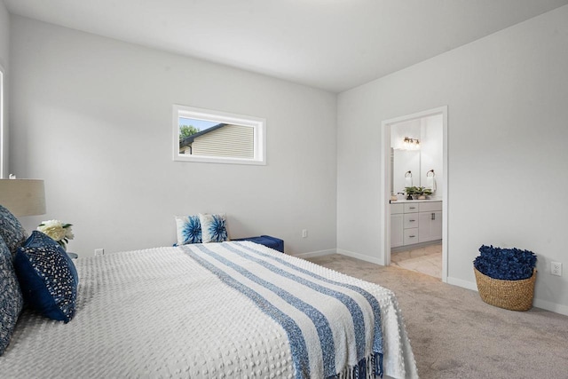 bedroom featuring baseboards, light carpet, and ensuite bathroom