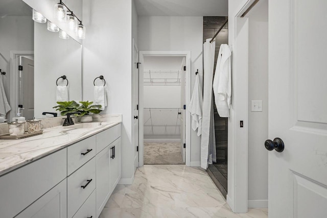 full bath featuring vanity, baseboards, curtained shower, a walk in closet, and marble finish floor