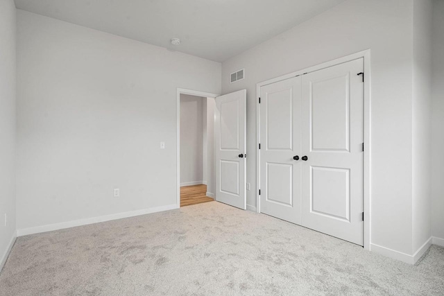 unfurnished bedroom featuring a closet, baseboards, visible vents, and carpet floors