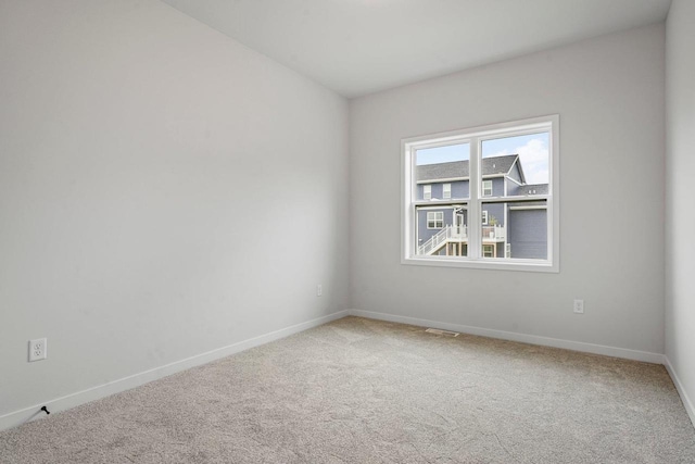 carpeted empty room with visible vents and baseboards