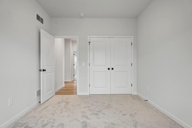 unfurnished bedroom featuring a closet, baseboards, visible vents, and carpet floors