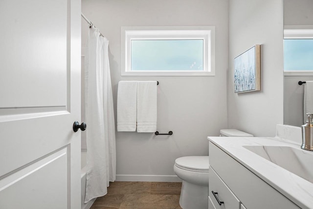 full bathroom featuring toilet, vanity, and baseboards