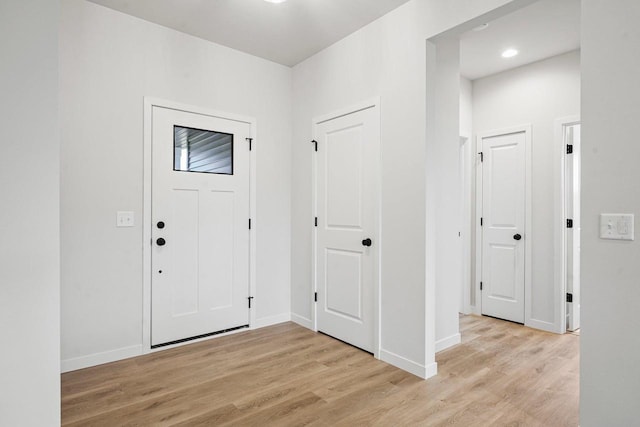 foyer entrance featuring light wood finished floors and baseboards